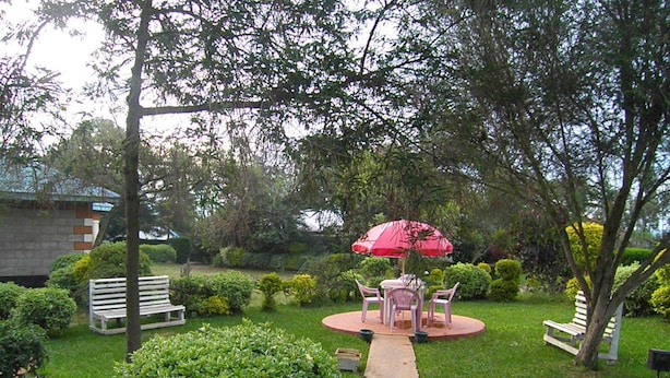 A garden with a central circular seating area, surrounded by benches and a pathway. - Imani Radio & TV Ministries (Kitale)