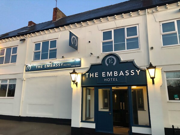 The Embassy Hotel with a classic facade, a prominent sign, and a welcoming entrance.