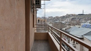 Varanda com vista para o horizonte urbano, cano de água e unidade de ar condicionado.