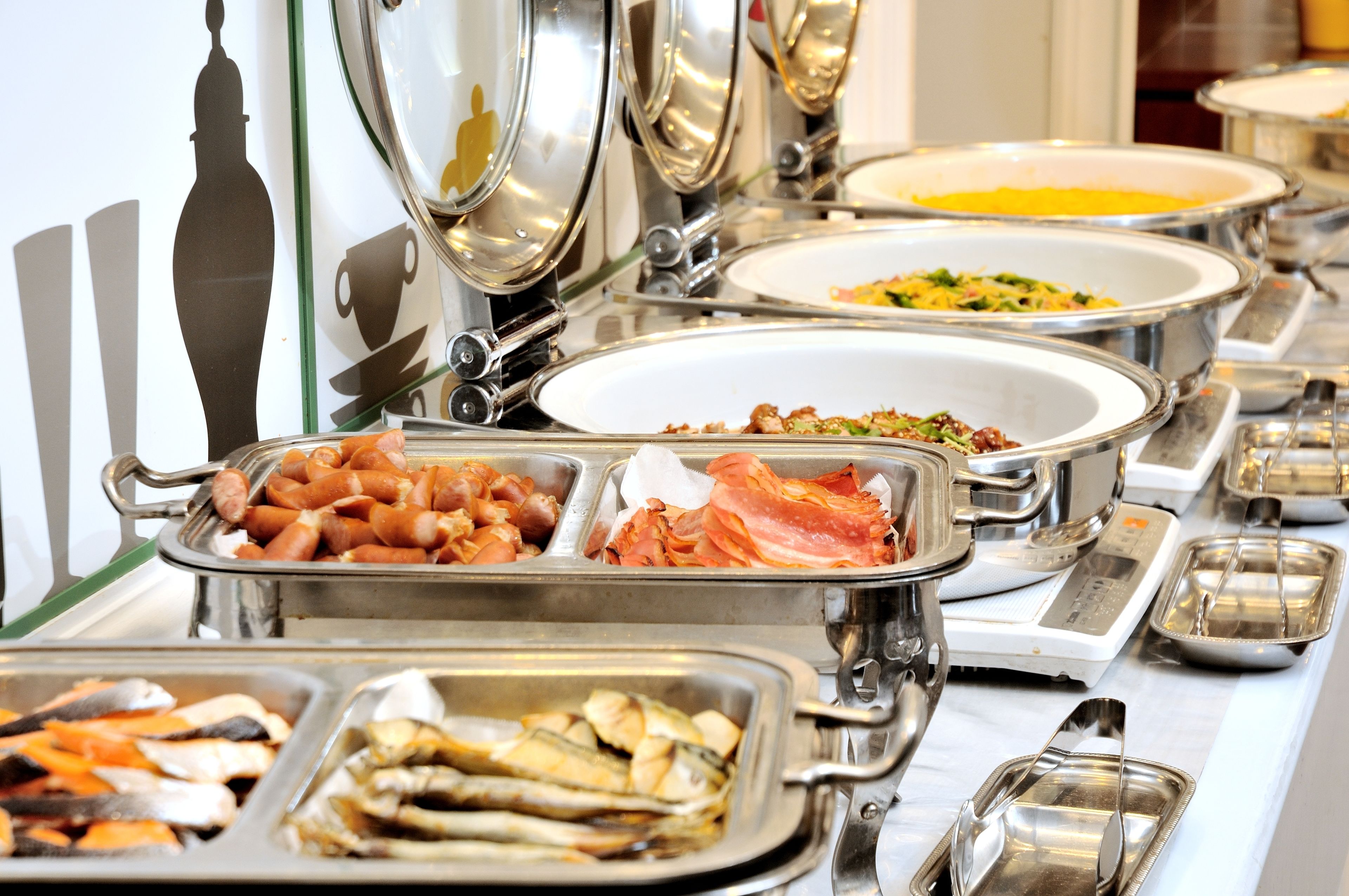 A buffet with various food items including meats, vegetables, and seafood.