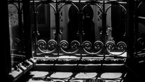 A black and white view of a wrought iron gate with intricate designs, leading to a building with a patterned facade. - Kasbah Ait Kassi (Souk Lakhmis Dades)