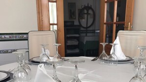 A dining table set with plates, cutlery, and wine glasses, with a chair visible in the background. - Hotel Mesón del Moro (Abaran)