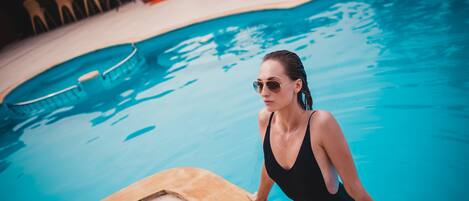 A swimming pool with a wooden deck edge.