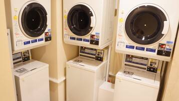 Three stacked coin-operated dryers in a row.