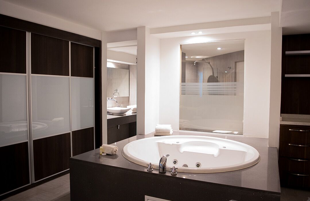 Un baño moderno con una bañera grande, un tocador con espejo y una ducha a pie.