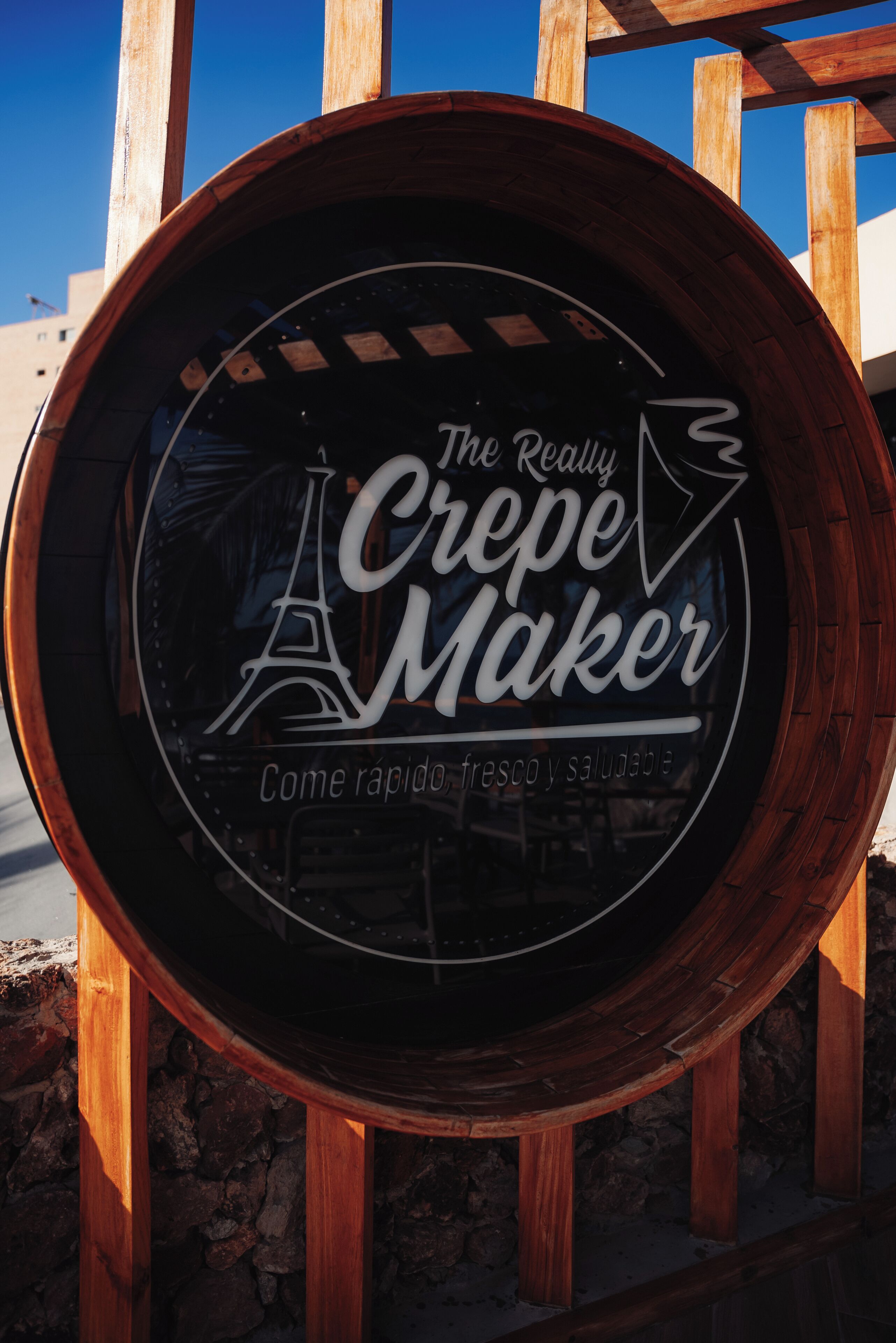 A circular sign with the text "The Really Crepe Maker" and a depiction of the Eiffel Tower.
