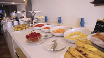 A buffet with various food items including fruits, pastries, and a sign indicating 'Bottega Free'.