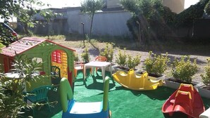 A children's play area with a small house, plastic chairs, and a slide. - Hotel Bel Air (Rimini)
