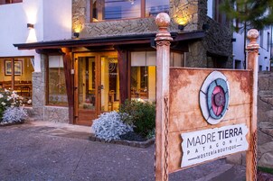 Un edificio de piedra con un letrero que dice "Madre Tierra Patagonia Hostería Boutique".