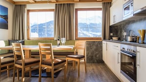 A modern kitchen with wooden cabinets, a built-in oven, and a window with a mountain view.