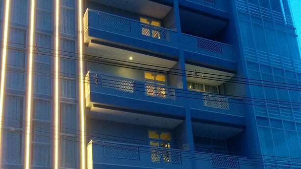 A multi-story building with illuminated signage and balconies.