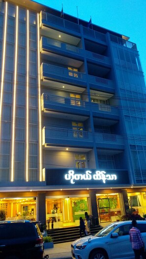 A multi-story building with illuminated signage and balconies.