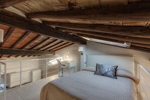 Un dormitorio con una cama grande, un escritorio y una silla.