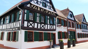Un edificio tradicional de entramado de madera con contraventanas verdes y un letrero que indica restaurante.