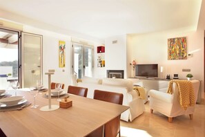 A modern living room with a dining area, a sofa set, a TV, and a fireplace. - Luxurious Penthouse with amazing views-Fl8-5 (Ojen)