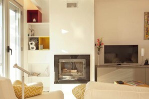 A modern living room with a fireplace, a flat-screen TV, and a bookshelf. - Luxurious Penthouse with amazing views-Fl8-5 (Ojen)