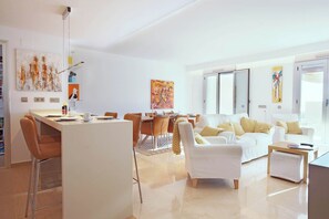 A modern living room with a dining area, white furniture, and artwork on the walls. - Luxurious Penthouse with amazing views-Fl8-5 (Ojen)