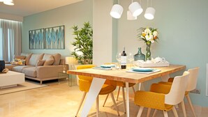 A modern dining area with a wooden table, yellow chairs, and a vase of flowers. - Modern Three bed ground floor apartment La Mairena (Ojen)