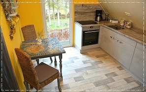 A kitchen with a dining table, chairs, and a coffee machine.