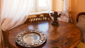 A round wooden table with a decorative metal tray and a classic table lamp. - Light Charme (Milan)