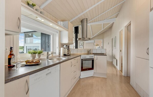 Enjoy cooking in this well-lit kitchen with an oven, stainless steel range hood, and dishwasher.