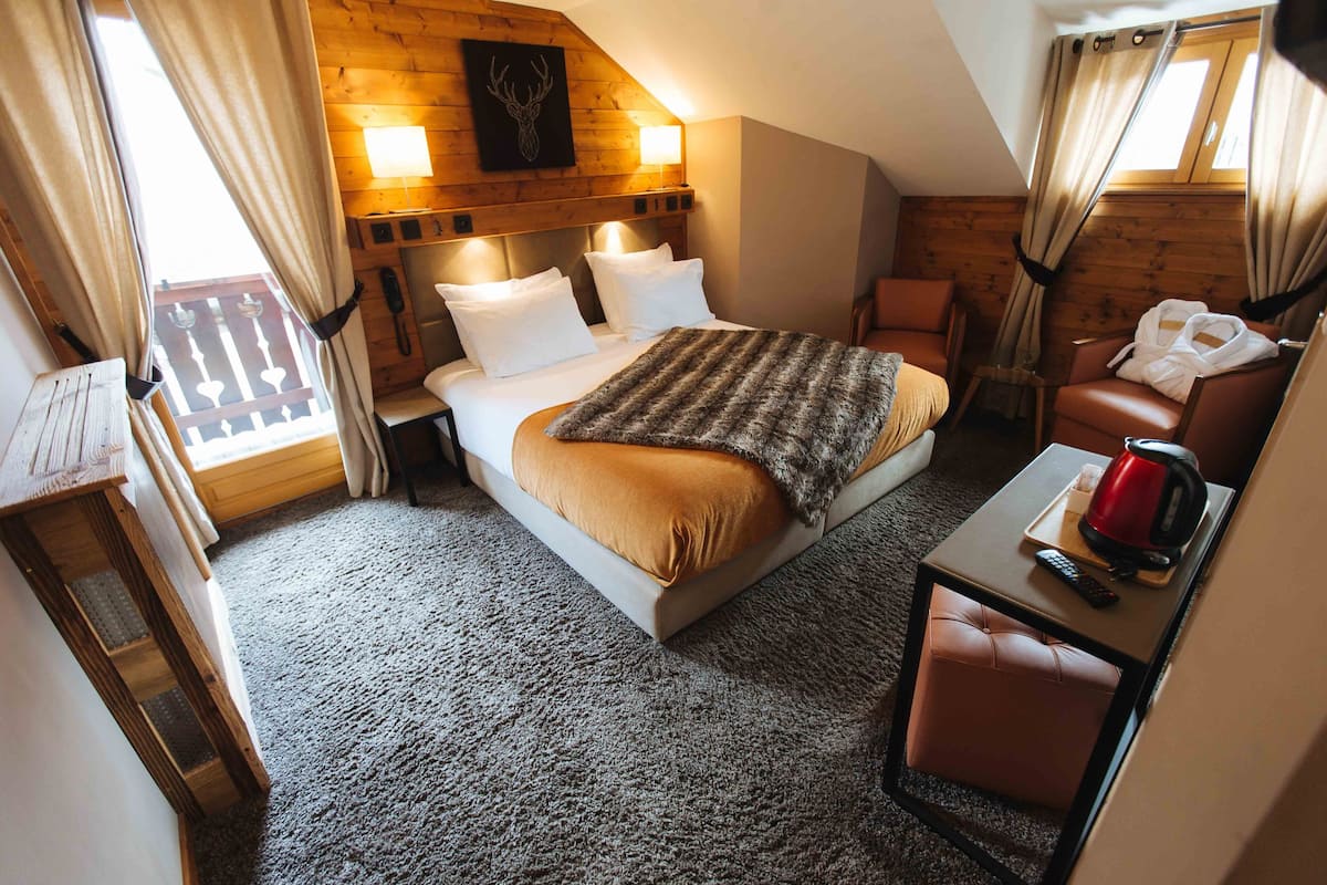 A cozy bedroom with a bed, bedside table, and a chair.