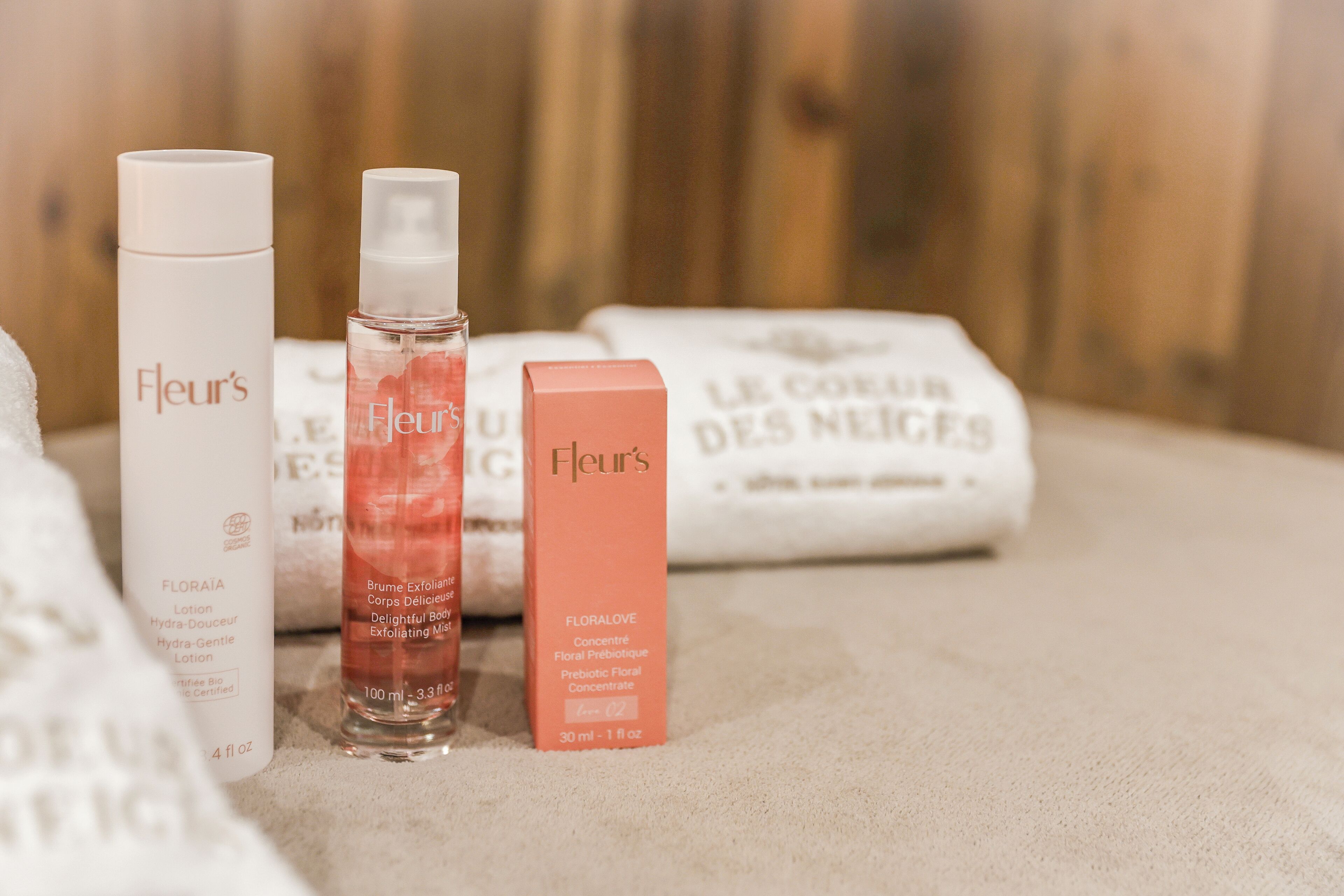 Eine Auswahl an Hautpflegeprodukten der Marke Fleur, darunter eine Lotion, ein Körper-Peeling-Spray und ein konzentriertes florales Präbiotikum.