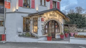 A hotel with a stone facade, red shutters, and a sign indicating it is a hotel. - Hôtel Le Coeur des Neiges (Saint-Gervais-les-Bains)