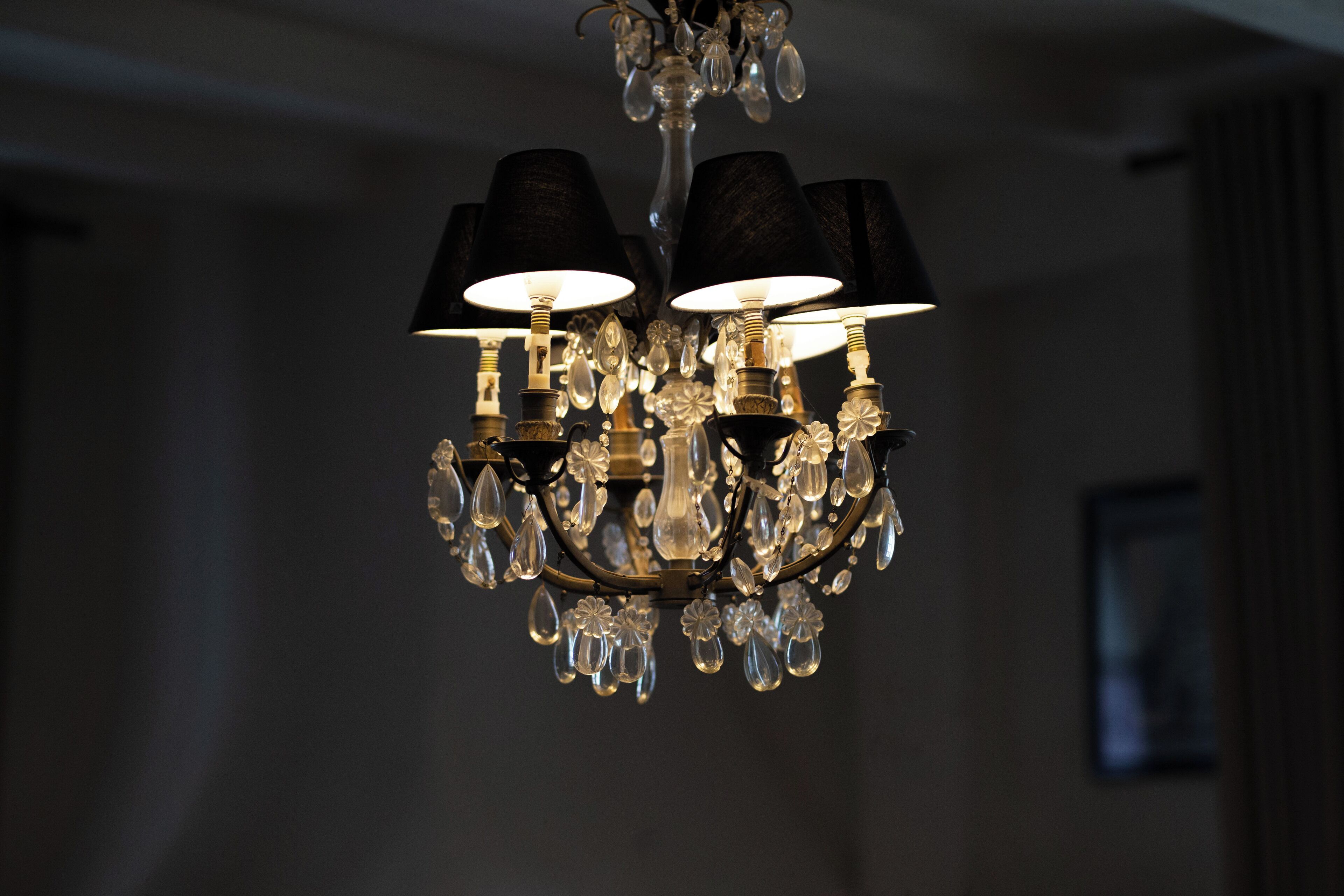 A chandelier with multiple lampshades and crystal decorations.