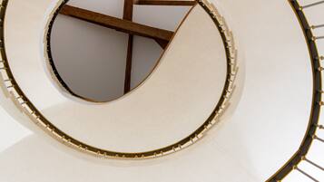 Elemento arquitectónico circular con una viga de madera y superficie blanca.