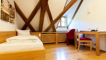 A bedroom with a wooden bed, a desk, and a chair.