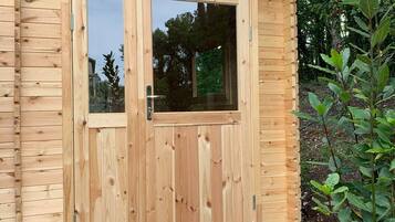 Een houten hut met een grote schuifdeur en een klein raam.