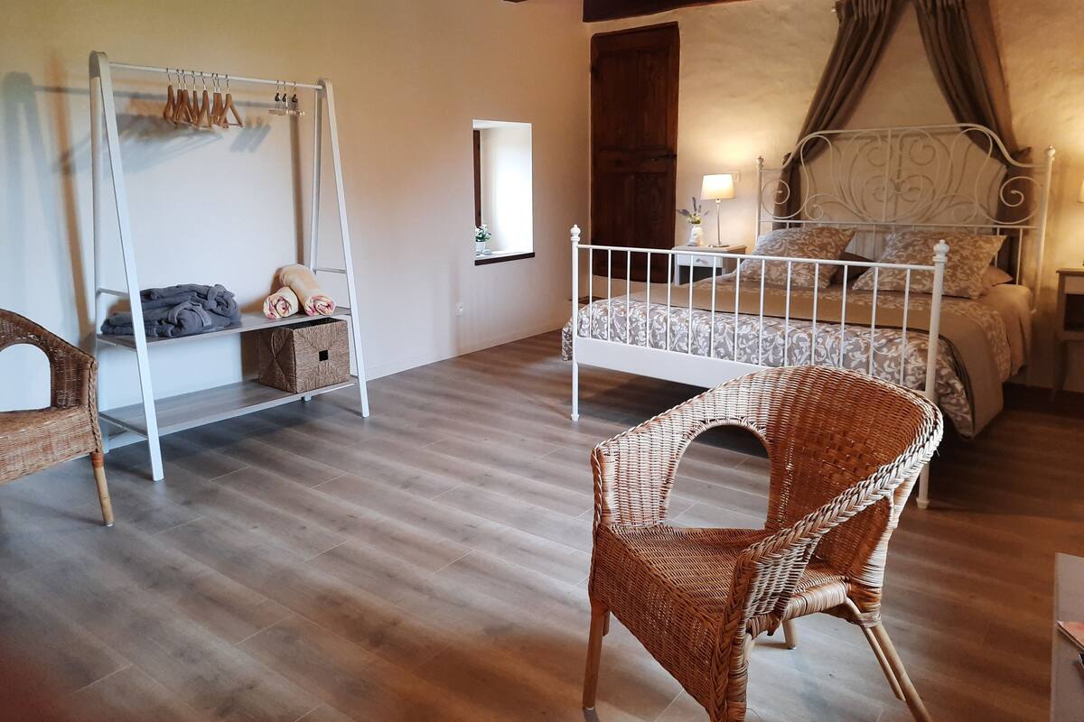 Une chambre à coucher comprenant un lit, une chaise, une armoire et un porte-vêtements.