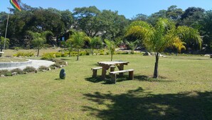 A picnic area with a table and benches, surrounded by grass and trees. - Beatrice Lodges and Conference Centre (Beatrice)