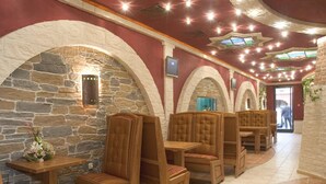 Un restaurante con arcos de piedra, cabinas de madera y suelo de baldosas.