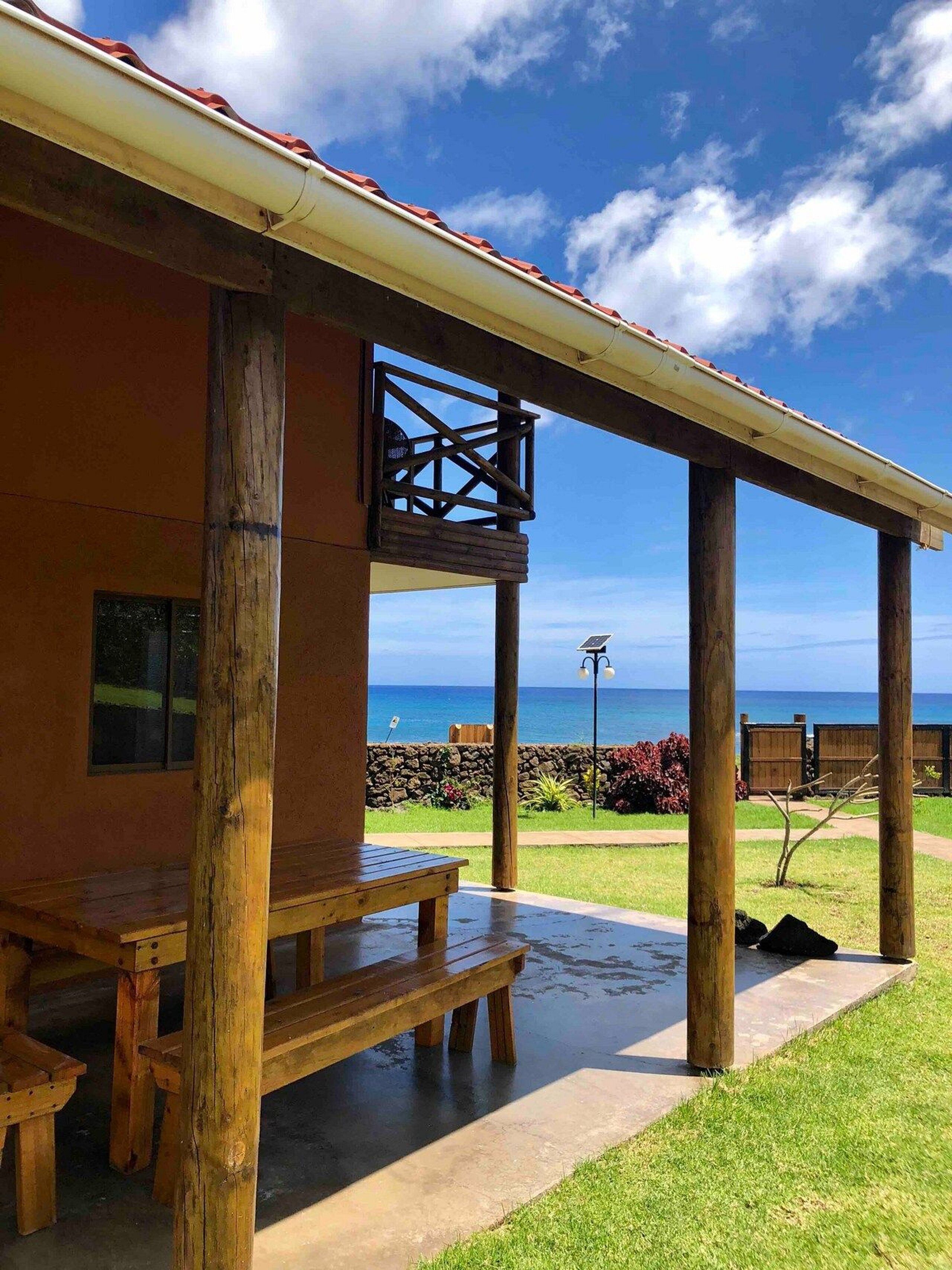 Una estructura de madera con balcón que da a una playa.