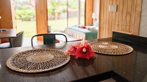 Une table à manger agrémentée de sets de table en fibres tressées et d’un arrangement floral décoratif.