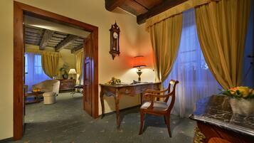 A room with a wooden desk, a chair, a clock, and a lamp.