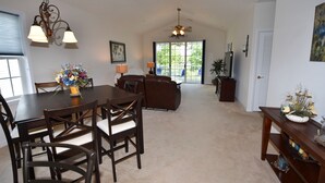 A spacious living area with a dining table, chairs, a sofa, and a ceiling fan. - Ironwood Apartment 1631 (North Myrtle Beach)