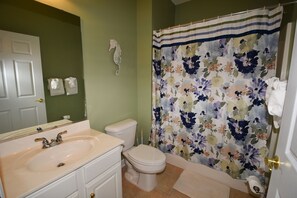 Ein Badezimmer mit Waschbecken, Toilette und Duschvorhang.