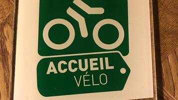 Letrero de bienvenida con un símbolo de bicicleta y el texto 'ACCUEIL VÉLO', que indica un alojamiento para ciclistas.