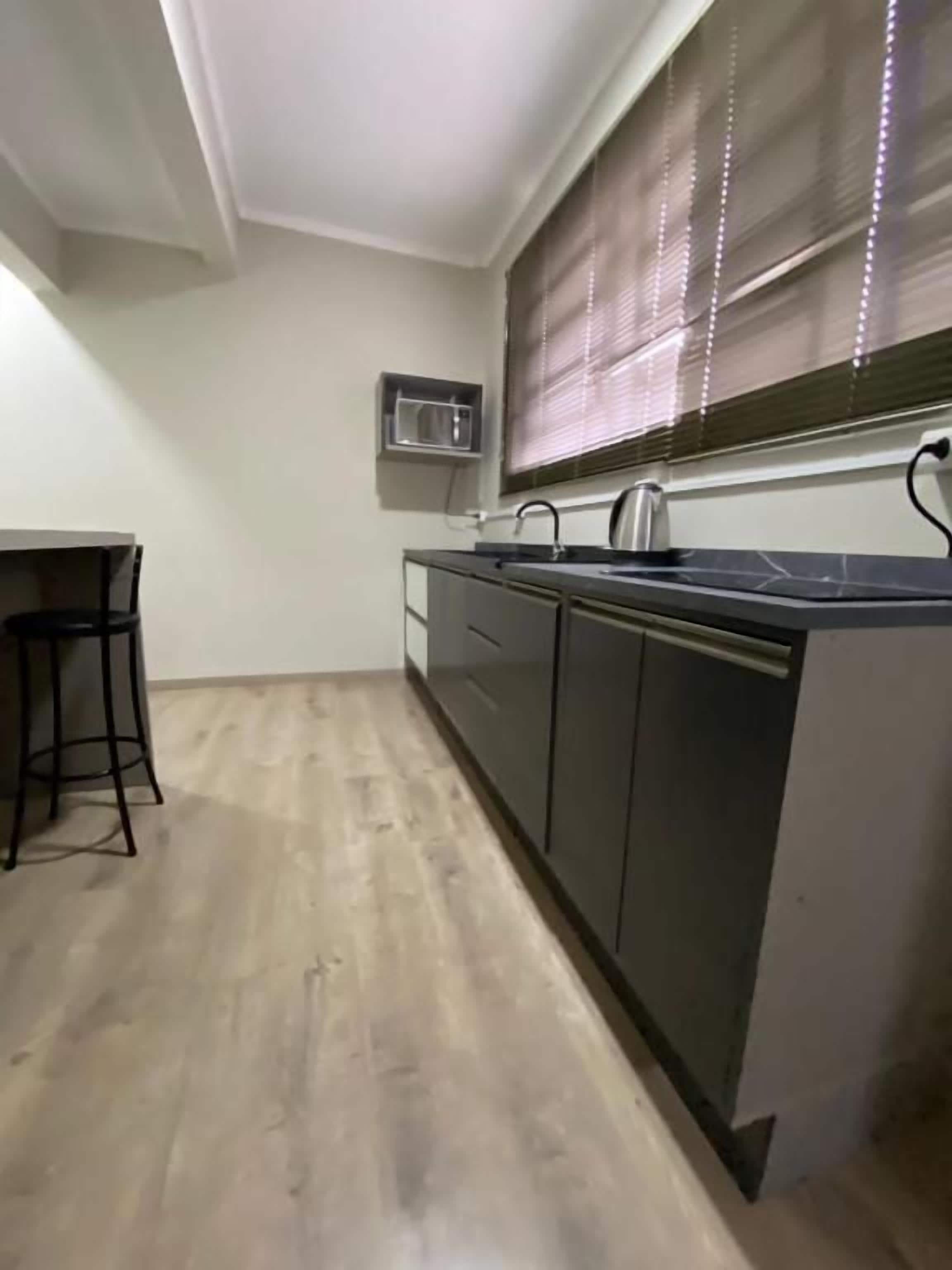 A kitchen with a countertop, sink, and cabinets.