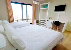 A hotel room with a large bed, a desk, a chair, and a TV mounted on the wall. - Hayer Hotel (Erechim)