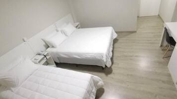 A room with two beds, a desk, and a chair.