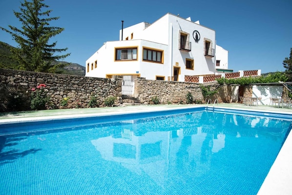 Et moderne hus i to etager med en swimmingpool foran.