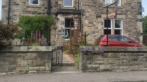 A stone building with a traditional design, featuring a prominent entrance and a sign indicating it is a guest house. - Dunclutha Guest House (Leven)