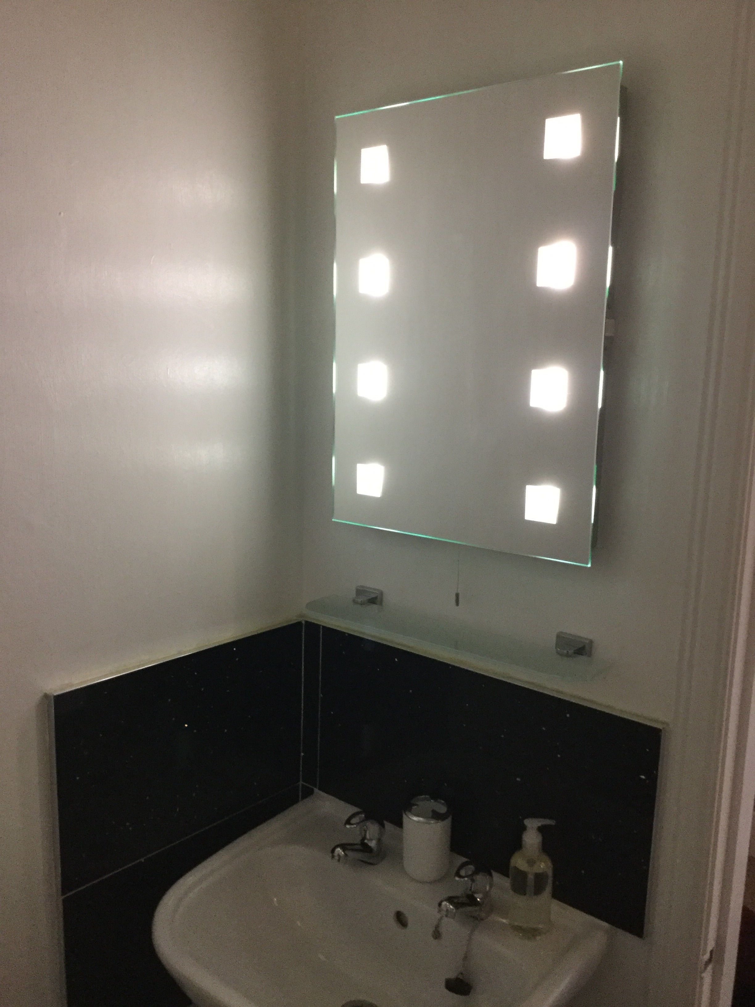 A bathroom with a sink, mirror, and toiletries.