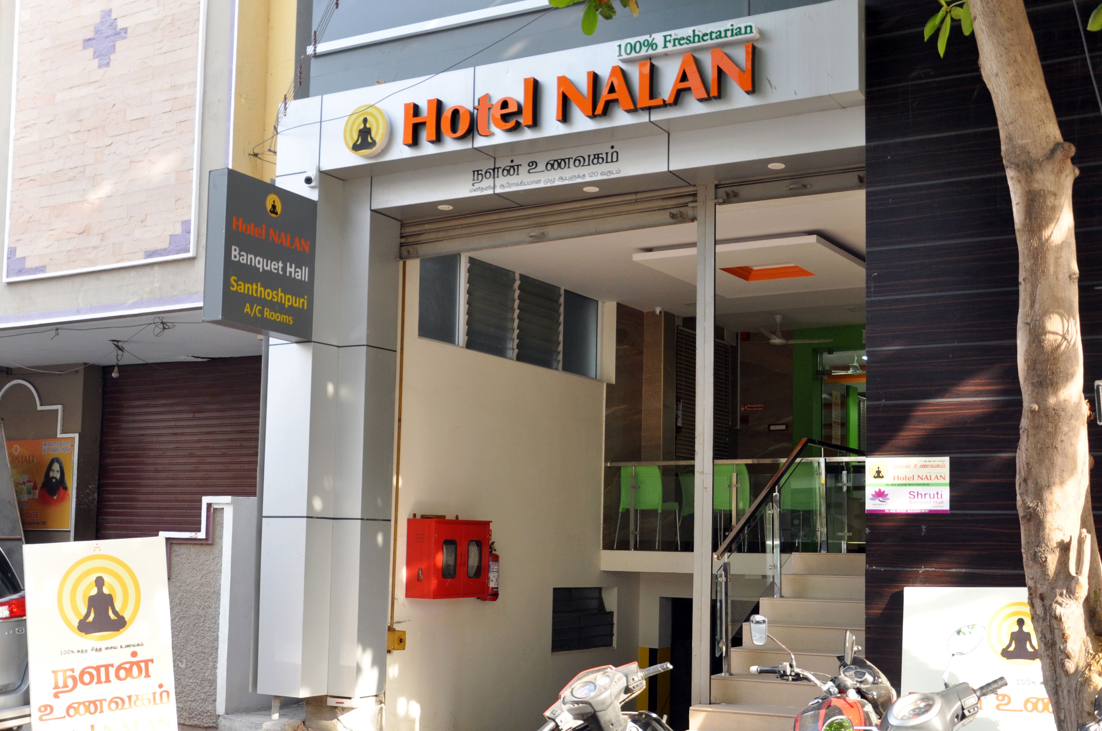 Hotel NALAN com um letreiro indicando quartos com ar condicionado e um salão de festas.