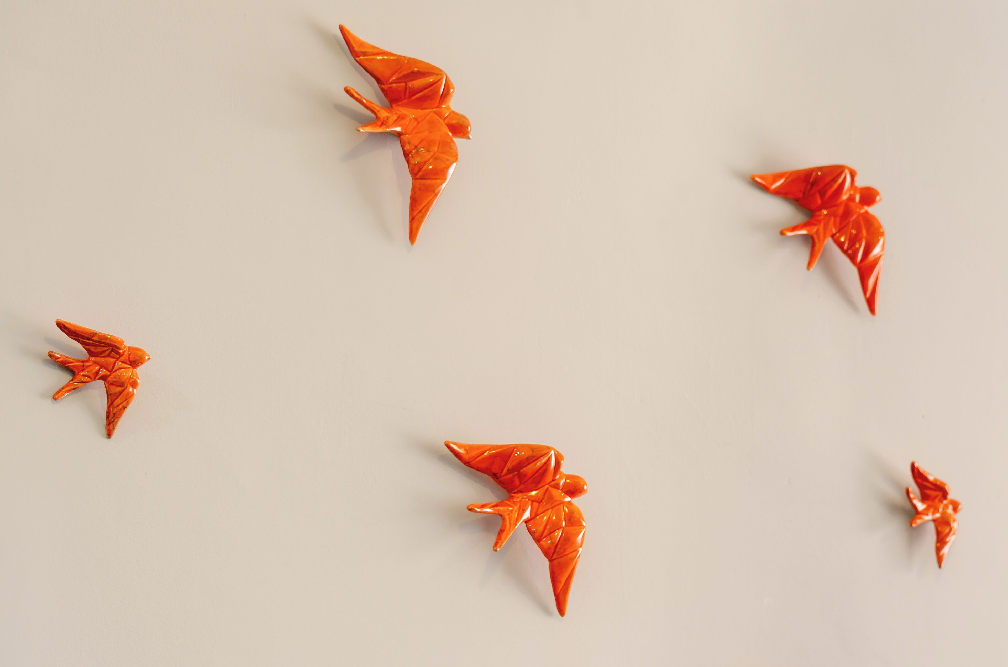 Vijf origami vogels tegen een effen achtergrond.