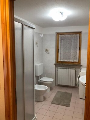 Departamento familiar, 1 habitación | Baño | Regadera, bidet, toallas 